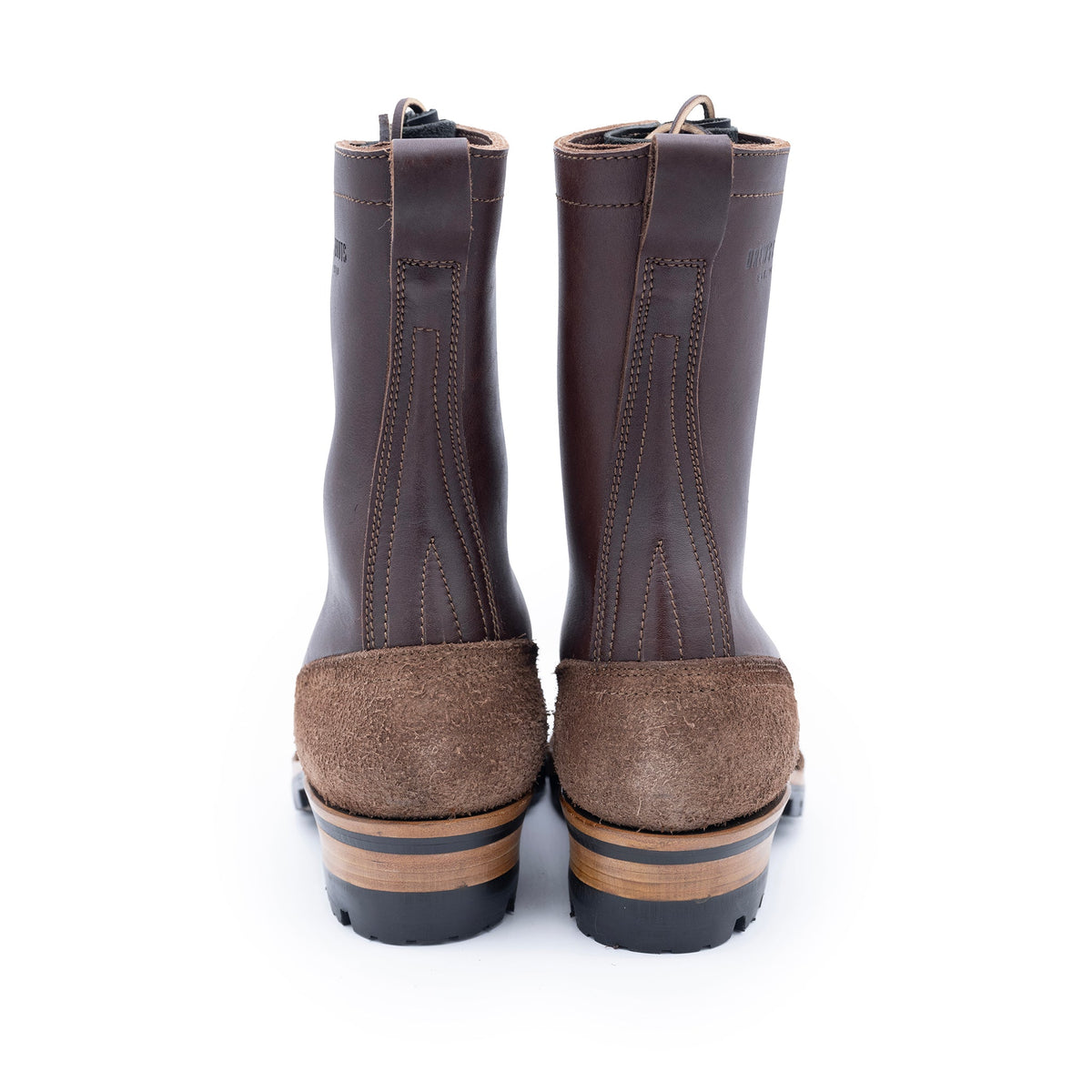 Pair of brown rubber boots with suede soles on a white background